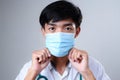 Close up face of a serious young male doctor in protective medical mask