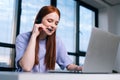 Close-up face of smiling young woman operator using headset and laptop during customer support at home office. Royalty Free Stock Photo