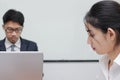 Close up face of unhappy Asian business woman having conflict with her colleague in office. Royalty Free Stock Photo