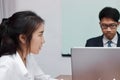 Close up face of unhappy Asian business woman having conflict with her colleague in office. Royalty Free Stock Photo