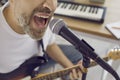 Close up of face of unrecognizable emotional male singer singing into microphone in studio. Royalty Free Stock Photo