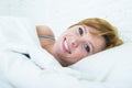 Close up face of young attractive woman with red hair lying in bed at home smiling happy looking healthy Royalty Free Stock Photo