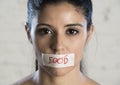 Close up face of young beautiful sad latin woman with mouth sealed on stick tape with the text no food Royalty Free Stock Photo