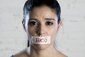 Close up face of young beautiful sad latin woman with mouth sealed on stick tape with the text no food Royalty Free Stock Photo