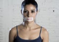 Close up face of young beautiful sad latin woman with mouth sealed on stick tape with the text no food Royalty Free Stock Photo