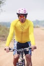 Close up face of young man riding mountain bike in dusty road us Royalty Free Stock Photo