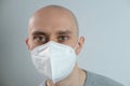 Close-up of face young man in white mask, protective respirator with high degree of protection class FFP2, COVID-19 coronavirus in