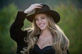 Close up face of young stylish woman in wide broad brim hat. Beautiful fashionable girl outdoor portrait. Happy smiling Royalty Free Stock Photo