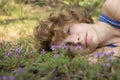 close-up face of a young woman lying on the grass in flowers. enjoyment of nature outdoors, relaxation, dreams