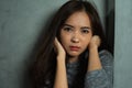 Close up face of young woman sitting sad, depression emotion, looking at camera in dark room Royalty Free Stock Photo