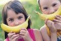 Close up faces of a beautiful young caucasian girl and boy with banana smile on nature background.
