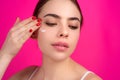 Close up facial cream on cheek. Beauty portrait of a beautiful half naked woman applying face cream isolated on studio Royalty Free Stock Photo