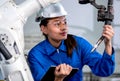 Close up factory worker woman maintenance and check part of robotic machine in workplace area. Industrial and technology support Royalty Free Stock Photo