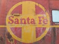 Close up of faded Santa Fe Railway logo on side of rusted rail car.