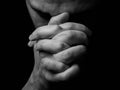 Close up of faithful mature man praying, hands folded in worship to god