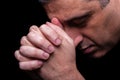 Close up of faithful mature man praying, hands folded in worship to god