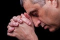 Close up of faithful mature man praying, hands folded in worship to god