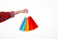 Close up of famale hand holding small colorful shopping bags over isolated white background Royalty Free Stock Photo
