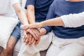 Close up of family with adult children and senior parents putting hands together sitting on sofa at home together. Family unity Royalty Free Stock Photo