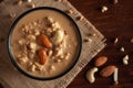 Close up of a famous Bengali dessert `Nolen Gurer Chanar Payesh` or Milk pudding of cottage cheese in a black bowl. Top-down view