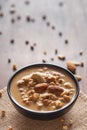 Close up of a famous Bengali dessert `Nolen Gurer Chanar Payesh` or Milk pudding of cottage cheese in a black bowl. Top-down view