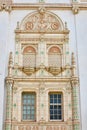 Close up of fancy golden and pastel green elaborate wall and windows of city hall building