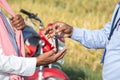 Close up of Farmer hands receiving keys from banker or corporate officer - concept of farmer bike or two wheeler loan