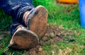 Close up of dirty feet feet crossed and resting on the ground. Famer\'s feet Royalty Free Stock Photo