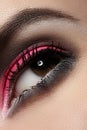 Close-up of fashion eyes make-up, bright magenta eyeshadow, dark eyebrows