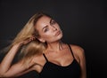 Close up fashion portrait of beautiful European woman with toned body, fresh clean tanned skin touching her shining blond hair and Royalty Free Stock Photo