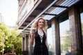 Close-up Fashion portrait of a young pretty fashionable girl posing in a city in Europe, summer street fashion, holding a coffe la Royalty Free Stock Photo