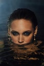 Fashion portrait of a girl in the pool. Woman`s Black swimsuit, turquoise water in the spa.