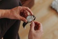 Close-up of a fashionable image of a luxury watch in hands. Detail of the body of a business man. Man's hand in brown pants pocke Royalty Free Stock Photo