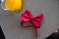 Fashionable red bow tie place with a glass orange juice ready for event party Royalty Free Stock Photo