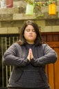 Close up of fat concentrating woman doing yoga exercise at outdoors, with both hands doing a pose, in a blurred