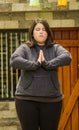 Close up of fat concentrating woman doing yoga exercise at outdoors, with both hands doing a pose, in a blurred