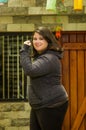 Close up of fat concentrating woman doing yoga exercise at outdoors, wearing sport clothes in a blurred background