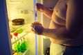 Close up of fat man break diet at night and eat unhealthy sweet Royalty Free Stock Photo