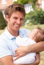 Close Up Of Father Cuddling Newborn Baby Boy Outdo