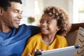 Close up of father and daughter using tablet computer, looking at each other smiling, selective focus Royalty Free Stock Photo