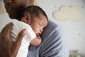 Close Up Of Father Holding Newborn Baby Son In Nursery