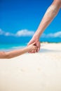 Close up of father and little daughter holding each other hands at beach