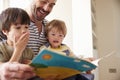 Close Up Of Father And Sons Reading Story At Home Together Royalty Free Stock Photo