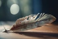 a close up of a feather on a wooden table with blurry lights in the background Royalty Free Stock Photo