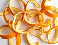 A vibrant arrangement of orange peels coiled gracefully on a neutral surface on white background Royalty Free Stock Photo