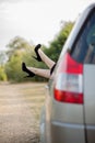 Close-up of feet with black shoes on high heels of attractive girl. She is putting her legs through the window of modern transport Royalty Free Stock Photo