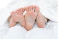 Close-up of the feet of a couple on the bed