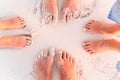 Close-up of the feet of family on the white sandy beach Royalty Free Stock Photo