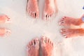 Close-up of the feet of family on the white sandy beach Royalty Free Stock Photo