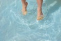 feet of a five-year-old boy who jumps, plays in the water in a children`s inflatable pool, splashes water